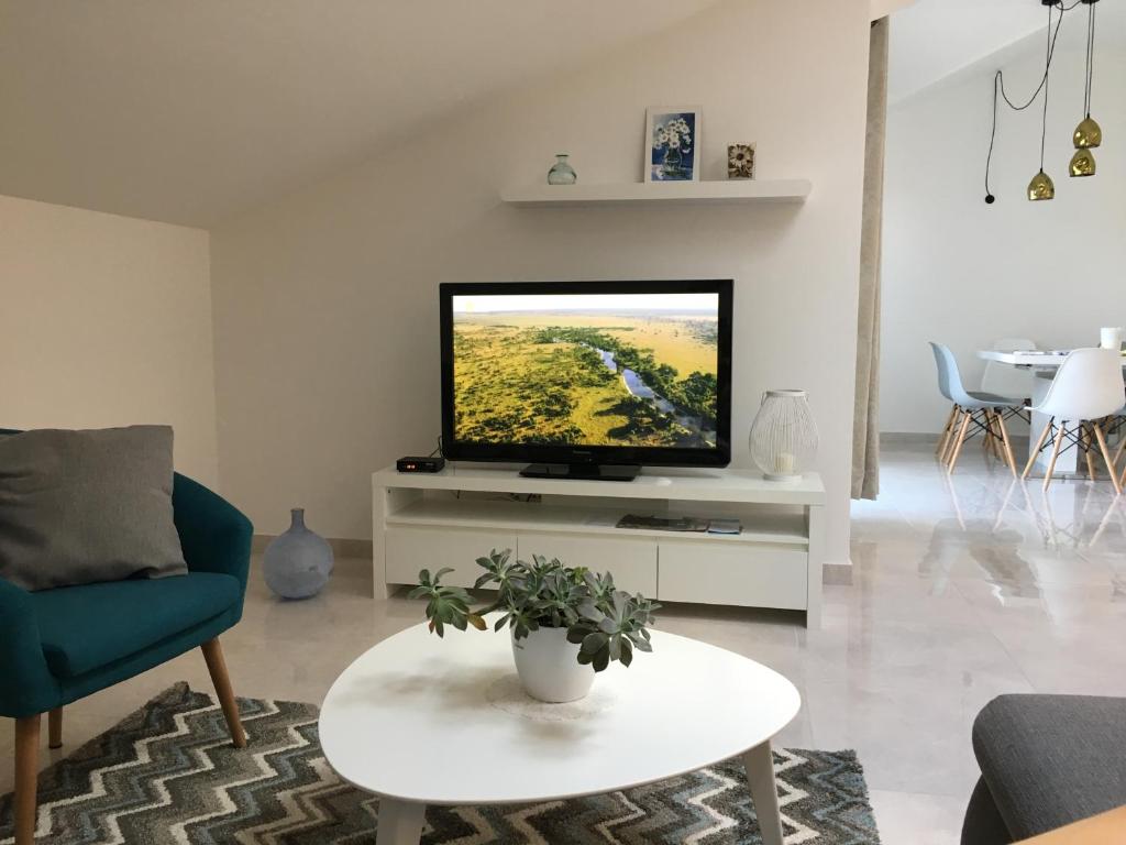 a living room with a flat screen tv on a white cabinet at Apartments Ladesta in Lastovo