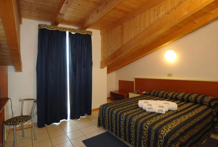 a bedroom with a bed and a blue curtain at Hotel Lido in Lido di Jesolo