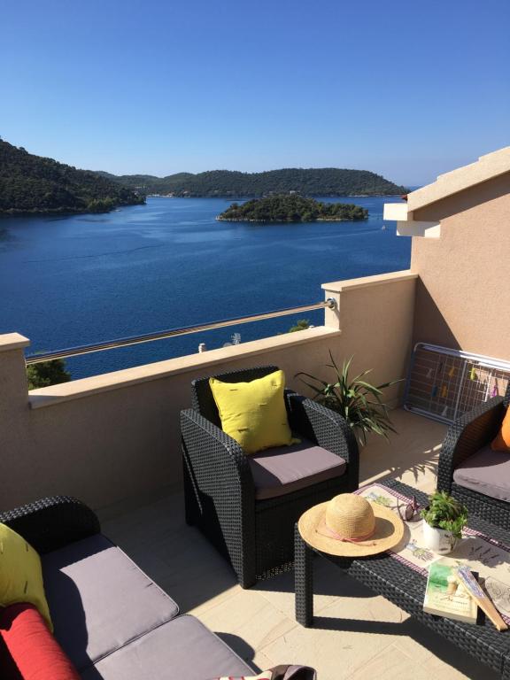 einen Balkon mit Stühlen und Blick auf das Wasser in der Unterkunft Apartments Ladesta in Lastovo