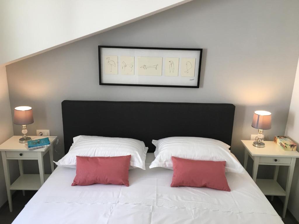 a bedroom with two white and red pillows on a bed at Apartments Ladesta in Lastovo