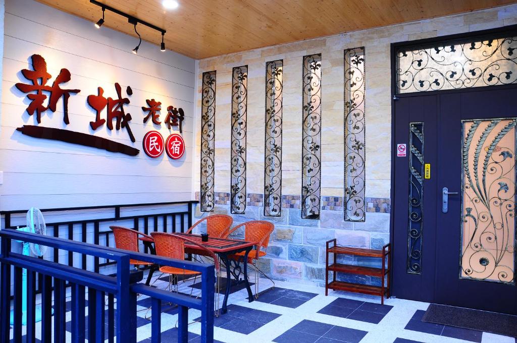 un ristorante con sedie arancioni, tavolo e porta di Xincheng Old Street B&B a Xincheng