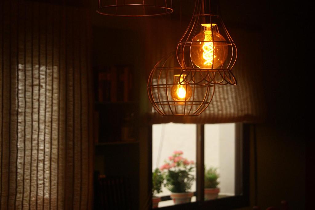 duas luzes penduradas num quarto com uma janela em La Siesta - En el corazón de Cordoba em Córdoba