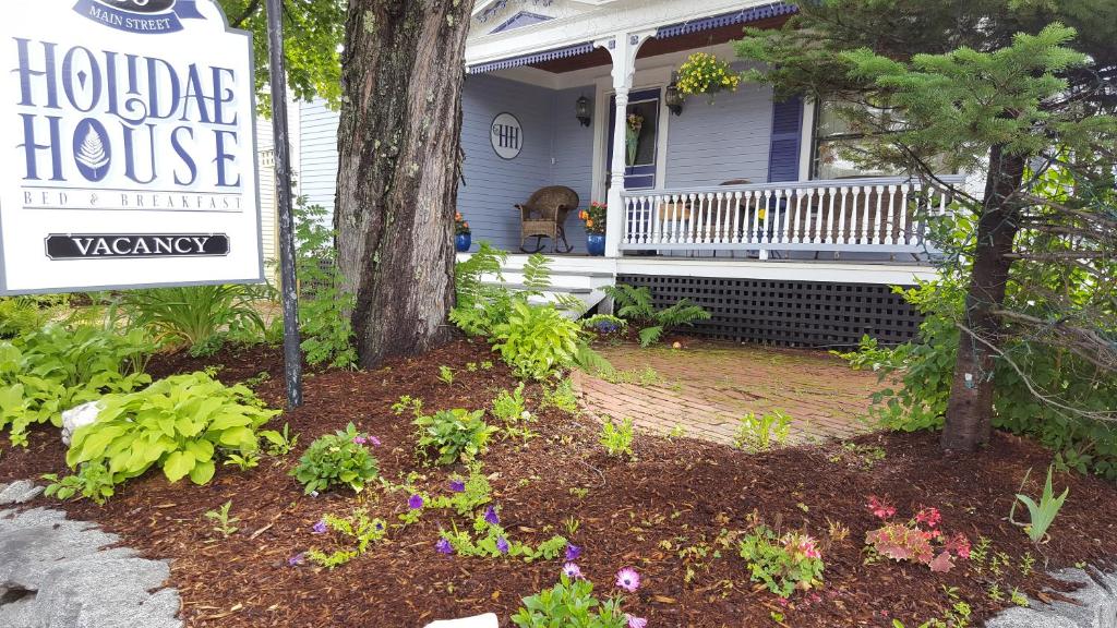 a sign in front of a house with a porch at Holidae House Bed & Breakfast in Bethel