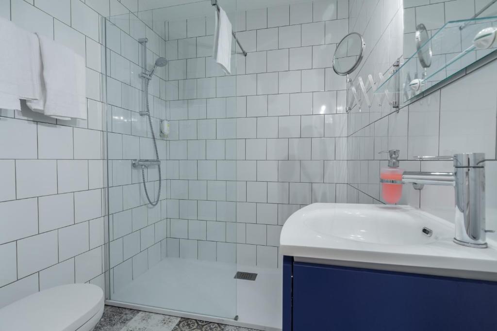 a bathroom with a shower and a sink and a toilet at Florella Marceau Apartment in Cannes