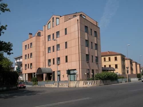 un grand bâtiment en briques sur le côté d'une rue dans l'établissement Hotel Borghetti, à Vérone