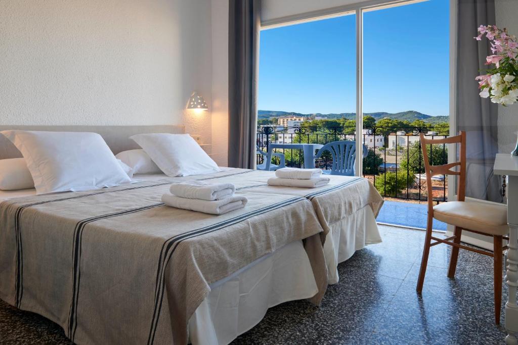 um quarto com uma cama com toalhas em Hotel Flamingo em Es Cana