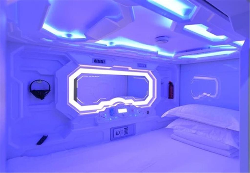 a bedroom with a bed and a tv in a room at Zhuhai Dreamers Capsule Hotel in Zhuhai