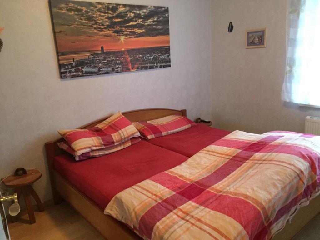 a bedroom with a bed with a red and yellow blanket at Huus 38c in Westerdeichstrich