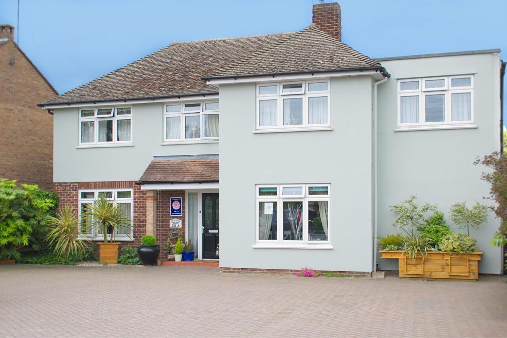 a white house with white windows and a driveway at The Cambridge Guest House by Tas in Cambridge