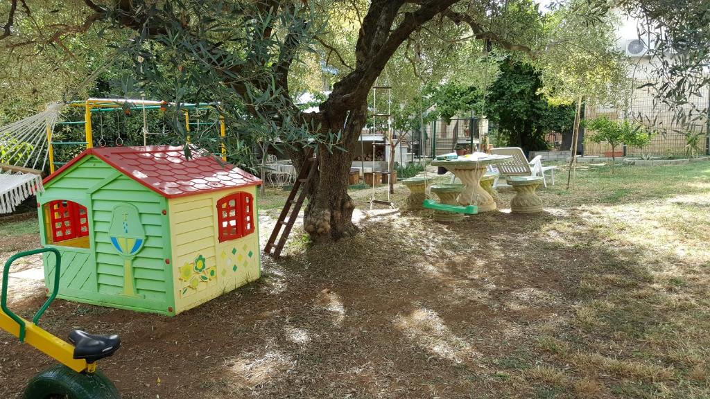 een speeltuin met een speelgoedhuis en een schommel bij B&B In Sabina in Poggio Nativo