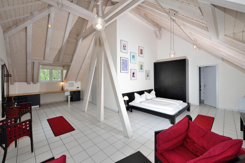 a living room with a bed and red chairs at Art Hotel Weimar in Weimar