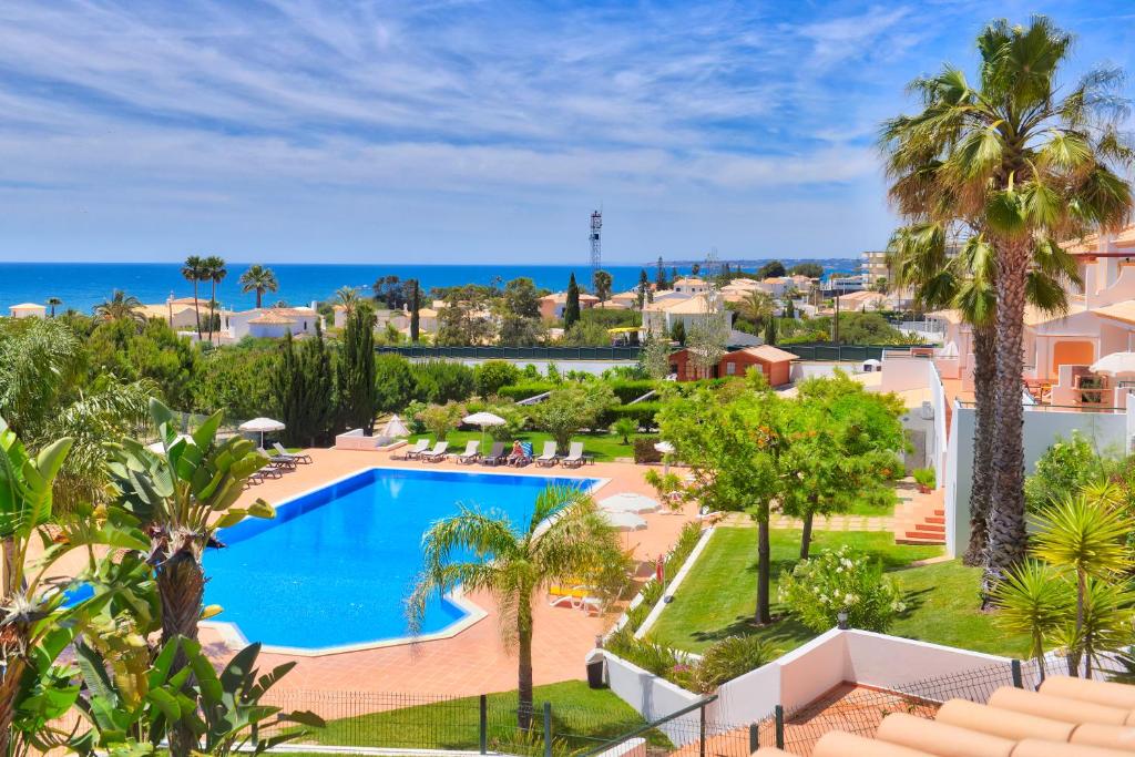 uma vista aérea de um resort com uma piscina e palmeiras em Moradias Villas Rufino em Albufeira