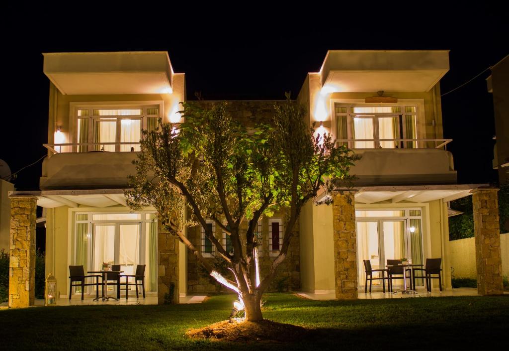 a house at night with a tree in front at Sunny Hill in Sani Beach