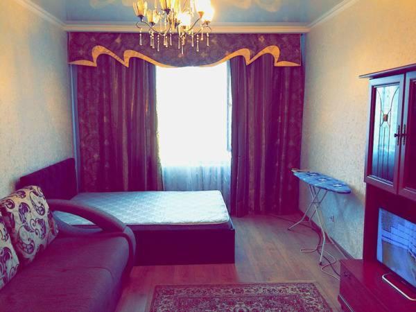 een woonkamer met een bank en een raam bij Infinity House in the center in Astana