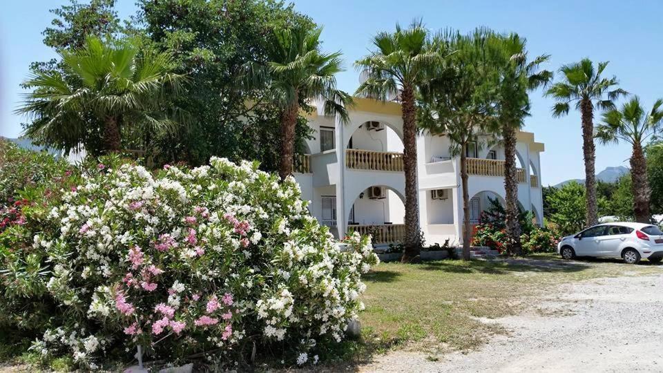 un gran edificio blanco con palmeras y flores en Paradise en Kyrenia