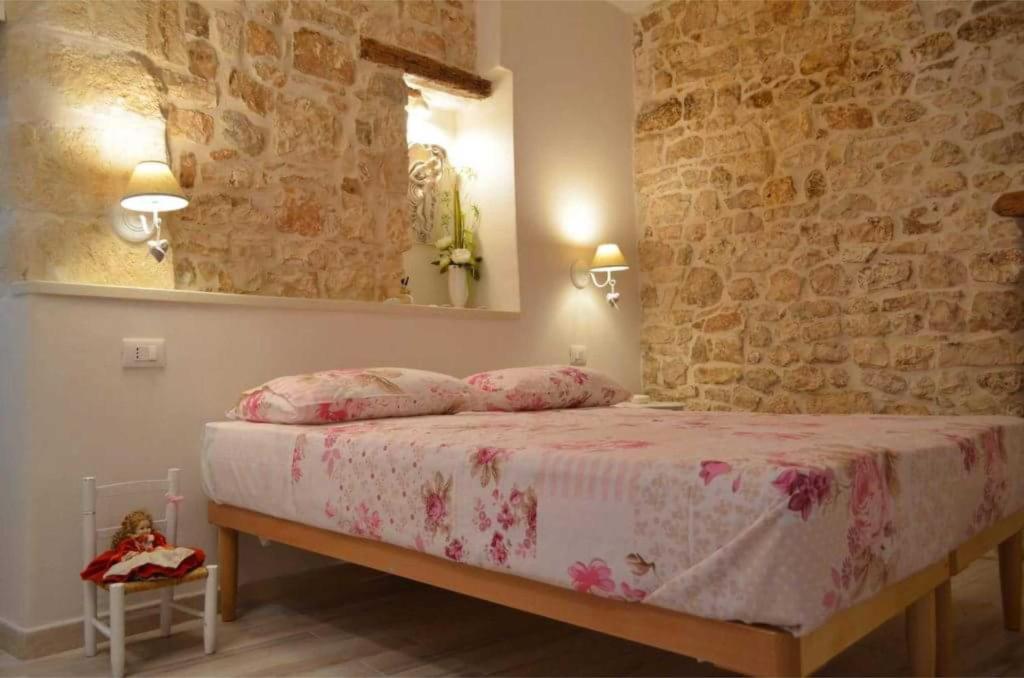 コンヴェルサーノにあるB&B Cieli di Danteのベッドルーム1室(ピンクのシーツと鏡付きのベッド1台付)
