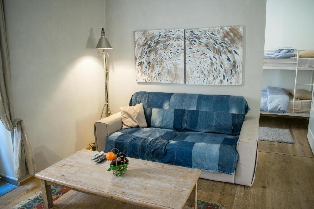 Melita corner apartment في فاليتا: غرفة معيشة مع أريكة زرقاء وطاولة قهوة