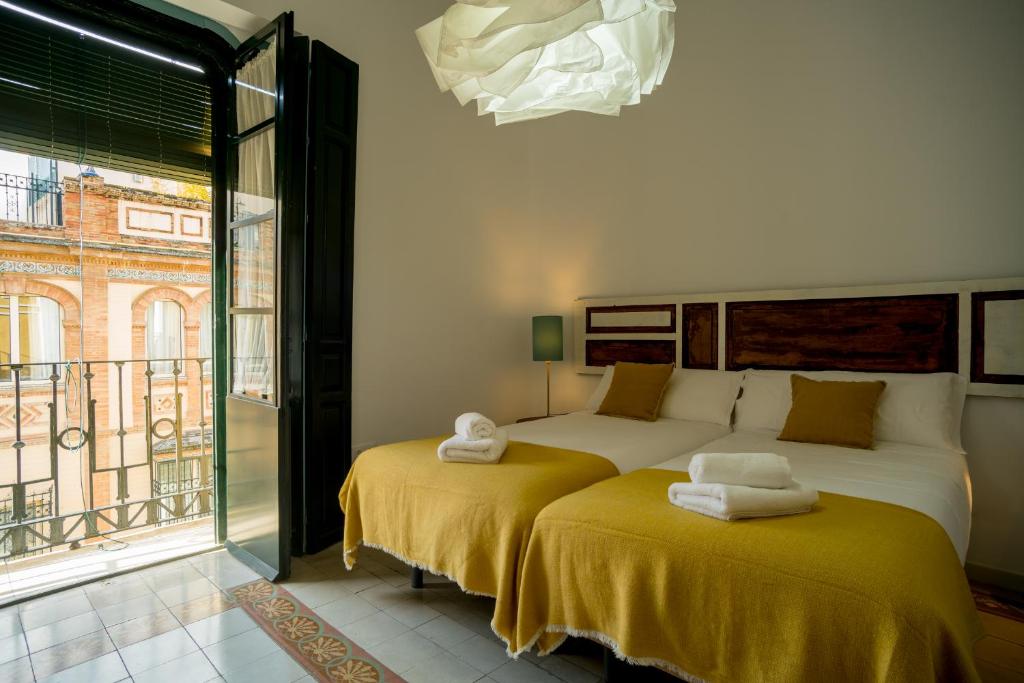 twee bedden met handdoeken erop in een kamer bij Eva Recommends Casa Gerona in Sevilla