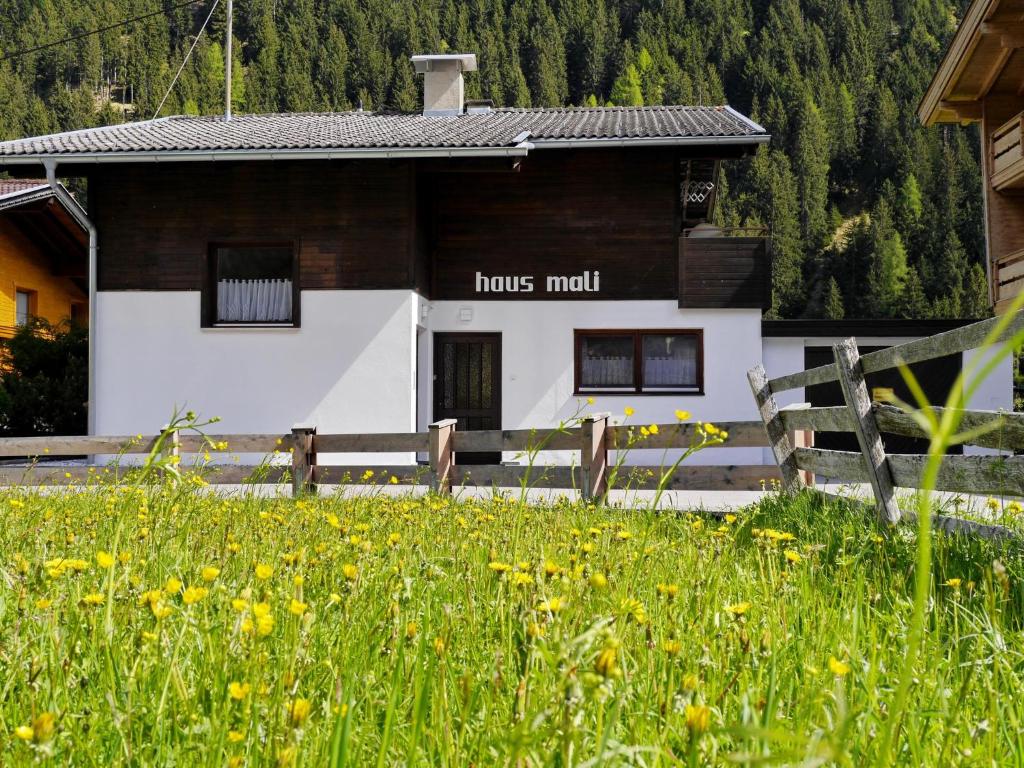 a house with a fence and a field of flowers at Haus Mali in Neustift im Stubaital
