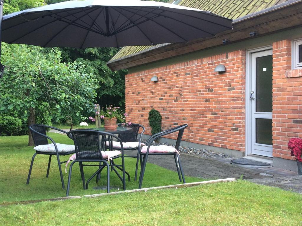 赫斯霍爾姆的住宿－Mikkelborg B&B，院子里伞下的桌子和椅子