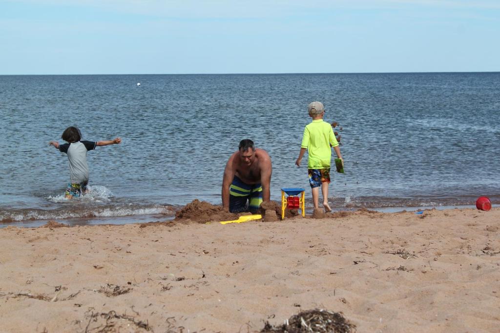 un grupo de personas jugando en la arena en la playa en Family Friendly Dream Home, en Murray Harbour