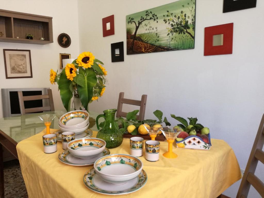 クストナーチにあるCasa Vacanze Siddaのひまわりと皿を盛ったテーブル