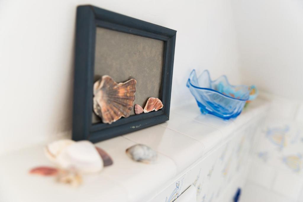 a picture frame on a counter with a fish figurine at Cristallo Verde Mare in Alba Adriatica