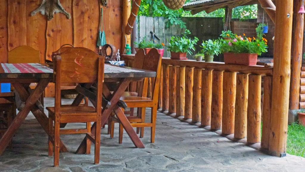 eine Terrasse mit einem Tisch, Stühlen und einem Zaun in der Unterkunft Sura Pietrei Craiului in Zărneşti