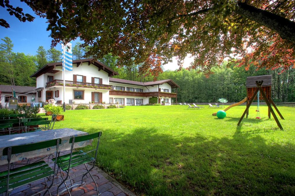 una casa grande con un patio con parque infantil en Haus Waldesruh en Übersee