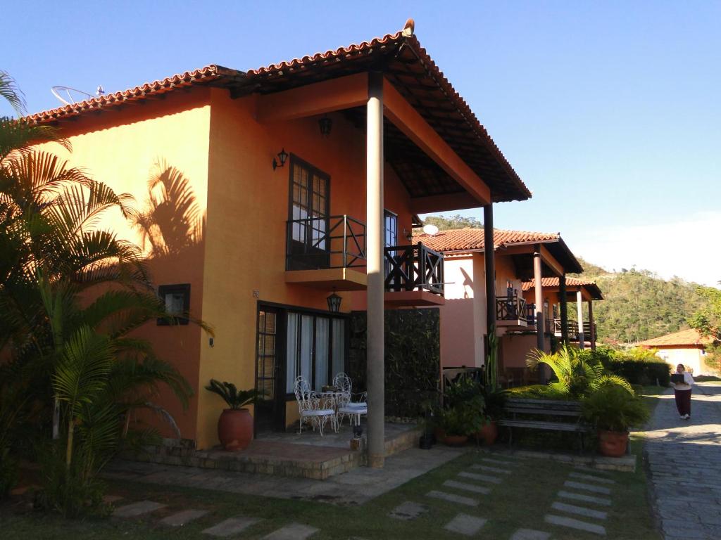 a yellow house with a table and chairs in front of it at Casa Temporada Itaipava in Petrópolis