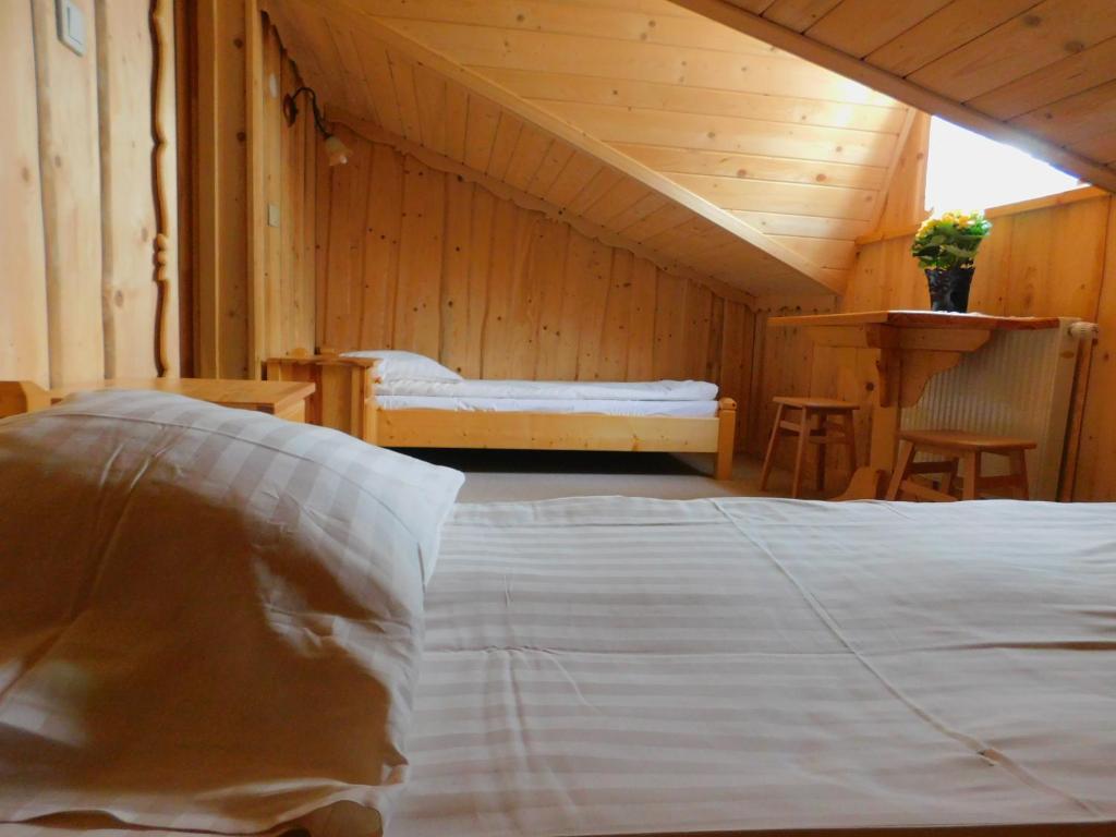 a bedroom with a white bed and a wooden ceiling at Dom wypoczynkowy U Kuby in Białka Tatrzańska