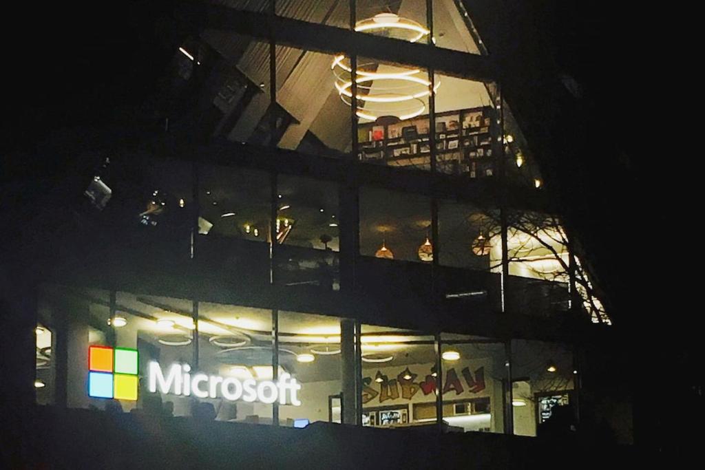 ミラノにあるROOM (boutique room)の夜間のマイクロソフトの看板が付いた大きな建物