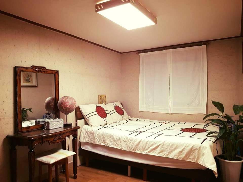 - une chambre avec un lit, une table et un miroir dans l'établissement Lydia Craft Guesthouse, à Séoul