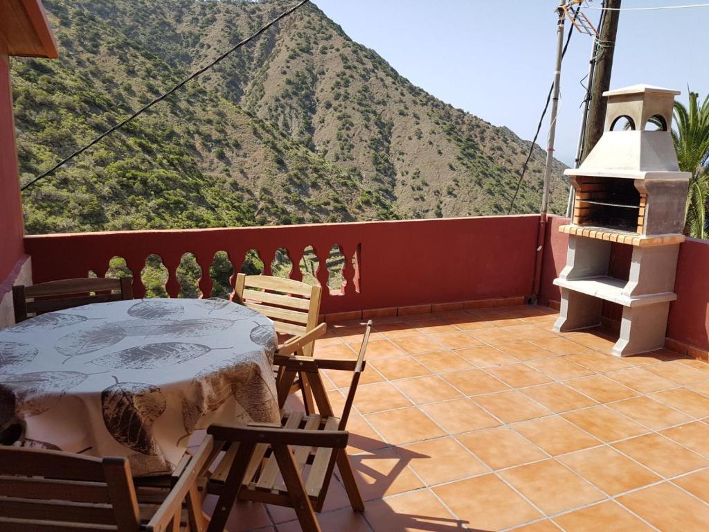 a balcony with a table and chairs and a mountain at Casa Rural Vicente in Vallehermoso