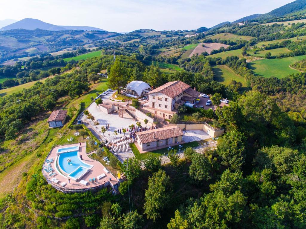 an aerial view of a house on a hill with a pool at La Castellaia Resort in Fabriano