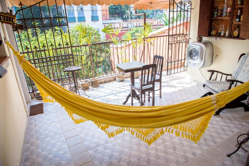 a hammock on a balcony with a table and chairs at Rio Antigo in Rio de Janeiro