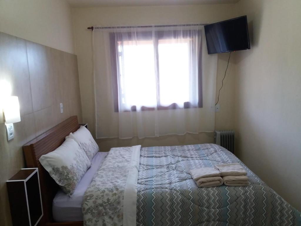 a bedroom with a bed with two towels on it at Apto Aconchegante na Serra Gaúcha in Nova Petrópolis