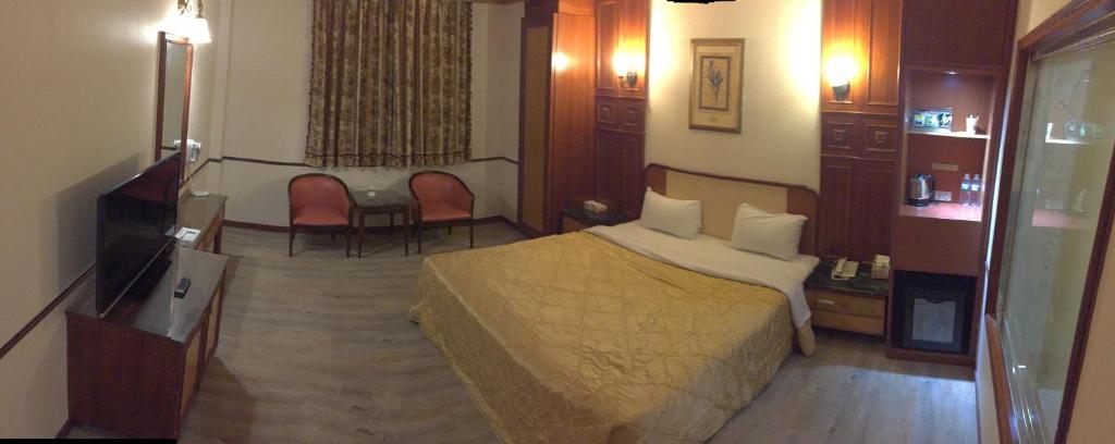 um quarto com uma cama, uma mesa e cadeiras em ChangSing Business Motel em Tainan