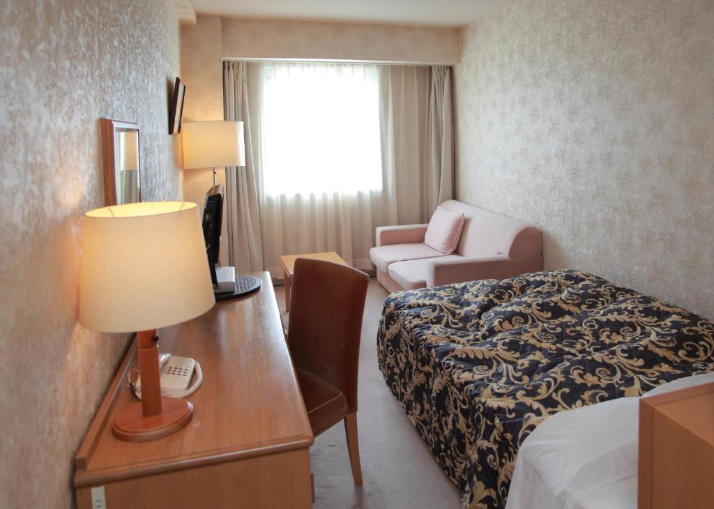 Postel nebo postele na pokoji v ubytování Saku Grand Hotel