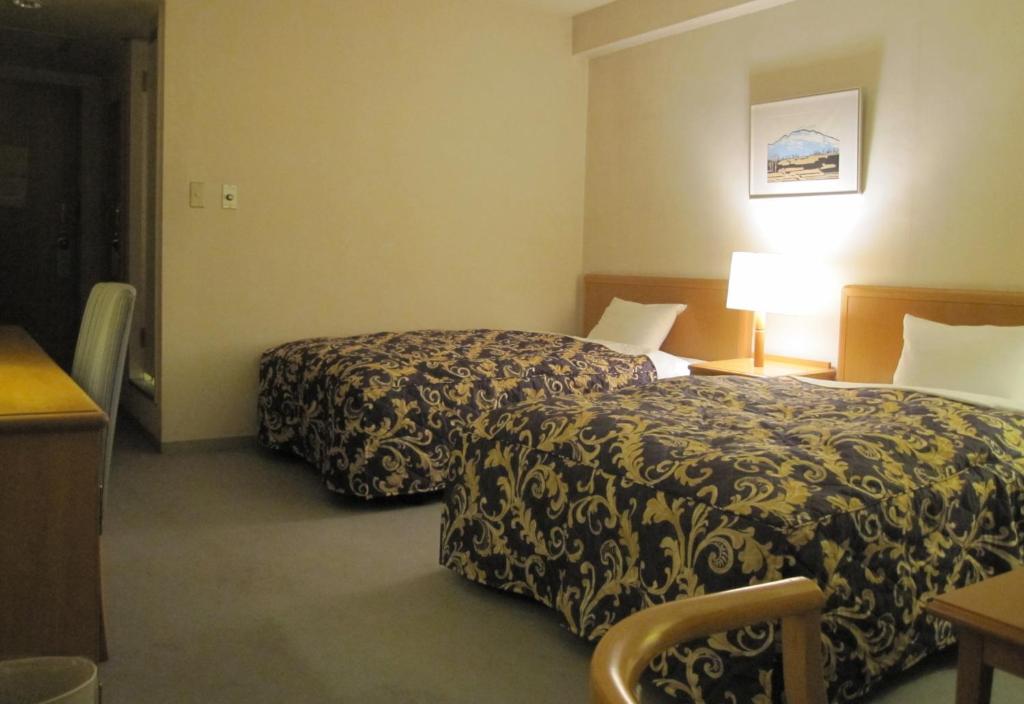 Postel nebo postele na pokoji v ubytování Saku Grand Hotel