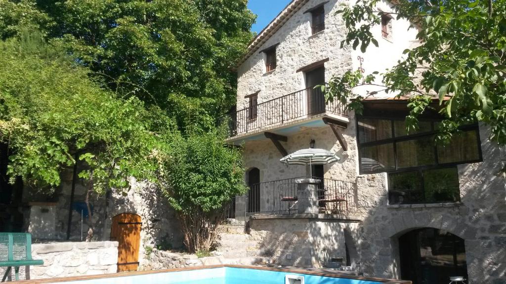 un edificio con balcone e piscina di Chambres d'hotes - La Maison de Julie a Entrevaux