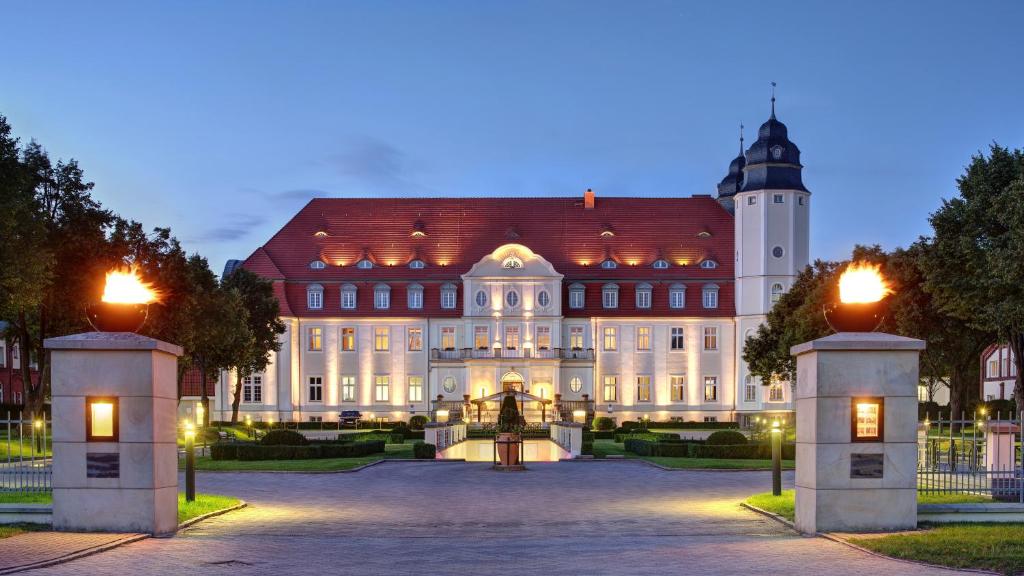 een groot gebouw met een klokkentoren ervoor bij SCHLOSS Fleesensee in Göhren-Lebbin