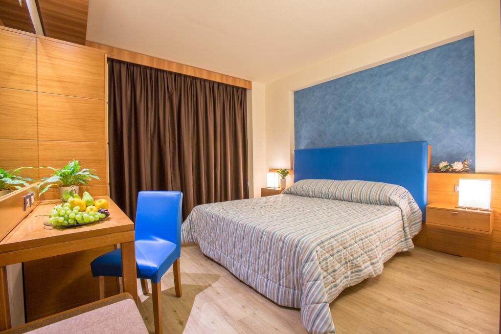 een hotelkamer met een bed en een tafel en stoelen bij Hotel Galilei in Pisa