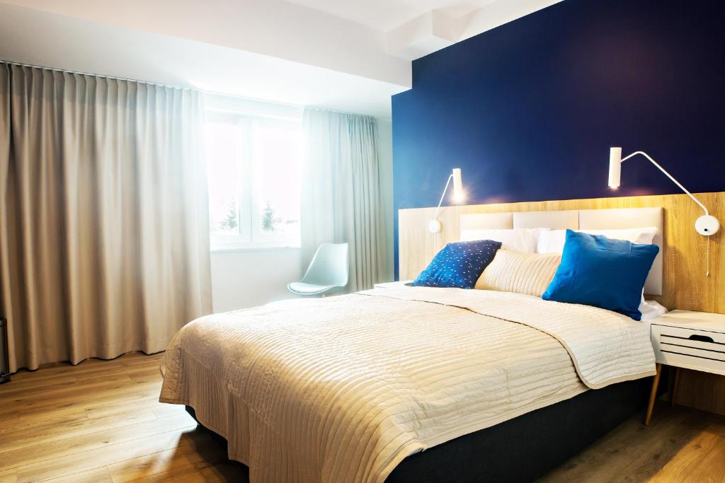 ヤロスワビエツにあるPokoje Deluxe Jarosławiecの青い壁のベッドルーム1室(大型ベッド1台付)