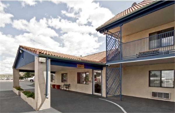 ein Gebäude mit einem Balkon und einem Parkplatz in der Unterkunft Travel Inn & Suite in Springerville