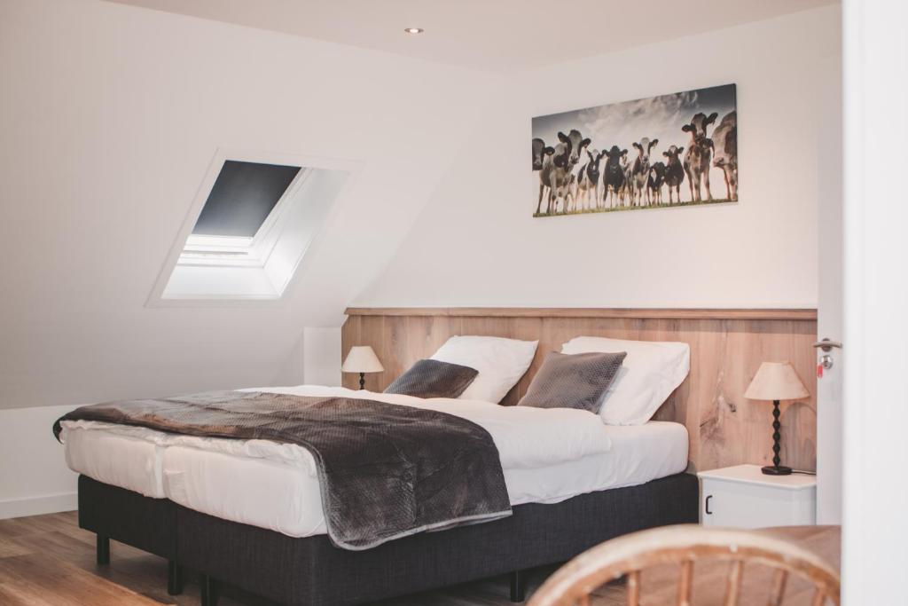 um quarto com duas camas e um quadro na parede em B&B Boerderij Zonneveld em Rossum