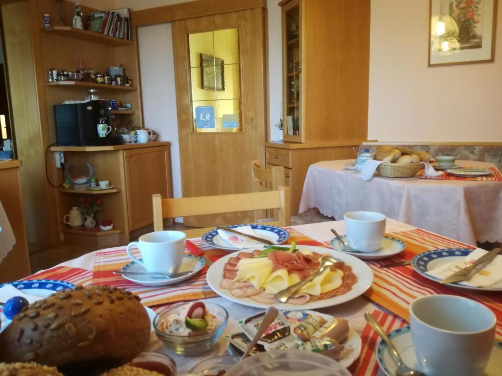 einen Tisch mit Teller mit Lebensmitteln darüber in der Unterkunft Gästehaus Dobida in Unterlamm