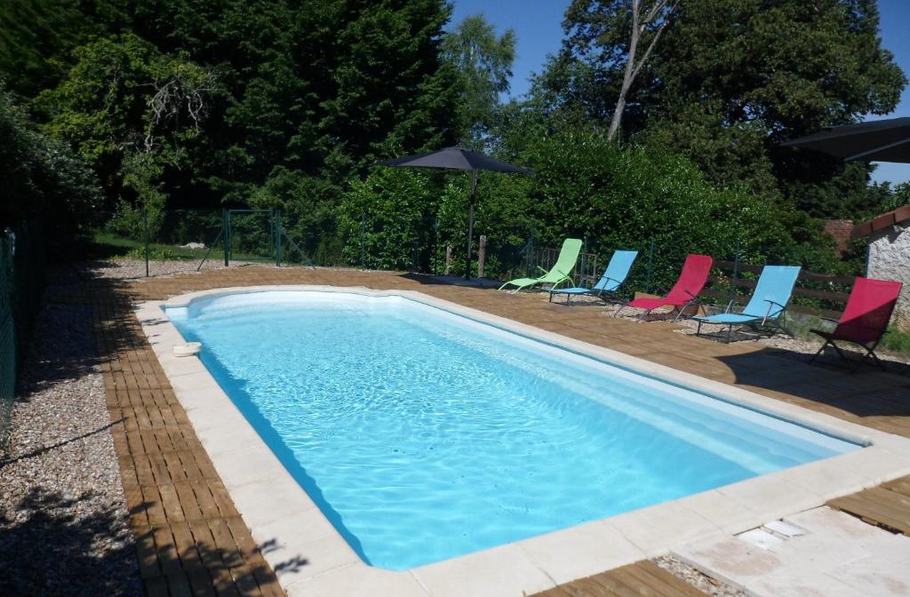une piscine avec chaises et parasols dans l'établissement Les gites de Pétrocoriis, à Boulazac