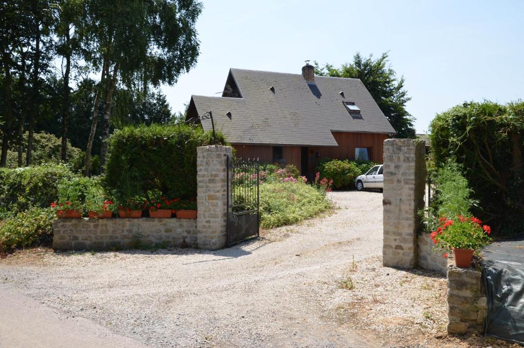 uma casa com um portão e flores em frente em Chambres d'hotes du creulet em Crouay