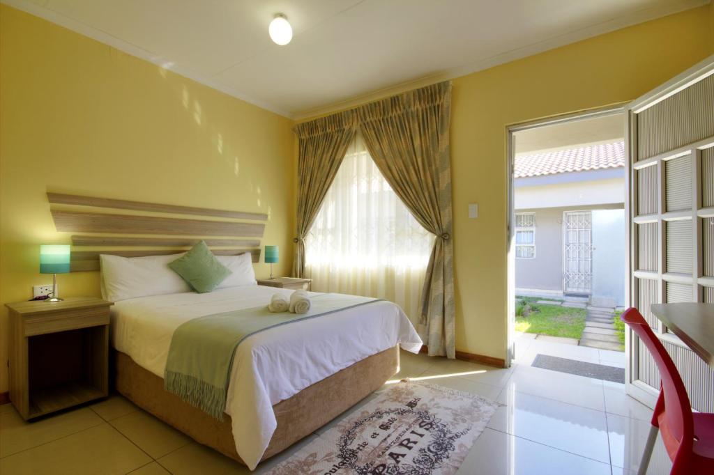 a bedroom with a bed and a large window at Minilitha Lodge in Richards Bay